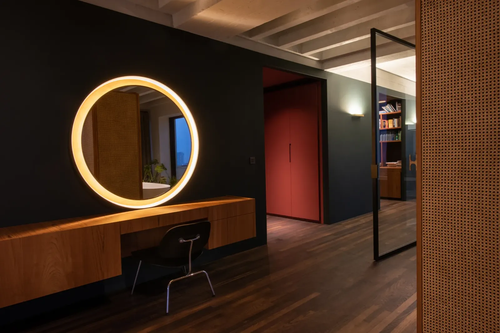 Donkergroene wand met ronde verlichte spiegel