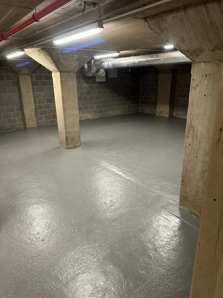 Gecoate vloer in een kelder met betonnen kolommen, schilderwerk voor een bedrijf in Antwerpen